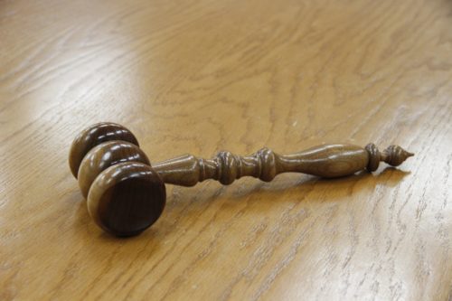 A wooden gavel lying on a wooden table, symbolizing authority in New Jersey Medical Marijuana legal proceedings.