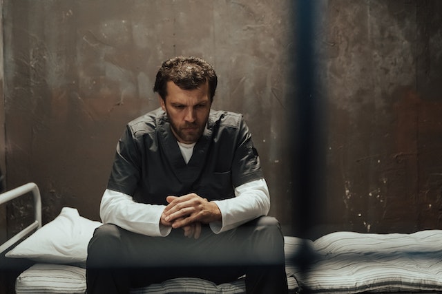 man sitting in cell