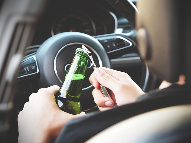 person opening beer in car