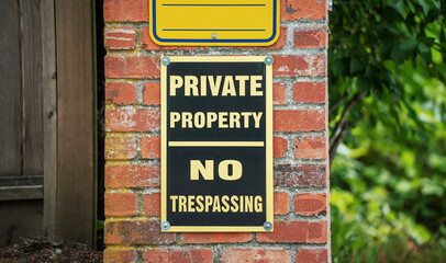 no trespassing sign on brick wall