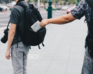 man stealing something out of backpack